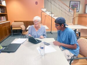 Wisdom to Wisdom club president Alex Jacob helps Laura Gilman with Google Docs and emails. (Photo by Shawna Levine)