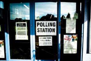 Polling station sign on door (Unsplash, free license)