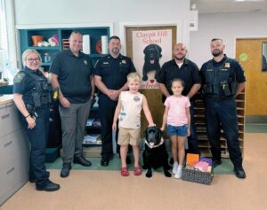 Wayland first responders and their four-legged helper visited the Claypit Hill School. Left to right: Officer Rachel Pugh, School Resource Officer Shane Bowles, Acting Chief Mark Hebert, Theo Burns, Archie, Hélène Genofre, Detective Sgt. Tyler Castagno, and Sgt. Christopher Custodie.