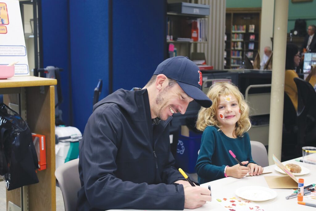 Josh Heulsen and his daughter Ada enjoying the arts and crafts table at Good Neighbor Day celebration. (Photo by Leticia Pinto)